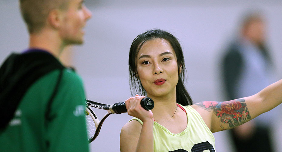 woman-with-racket-talking-to-coach