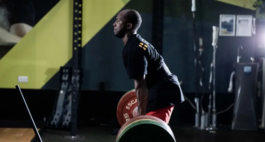 A gym member lifting a barbell.