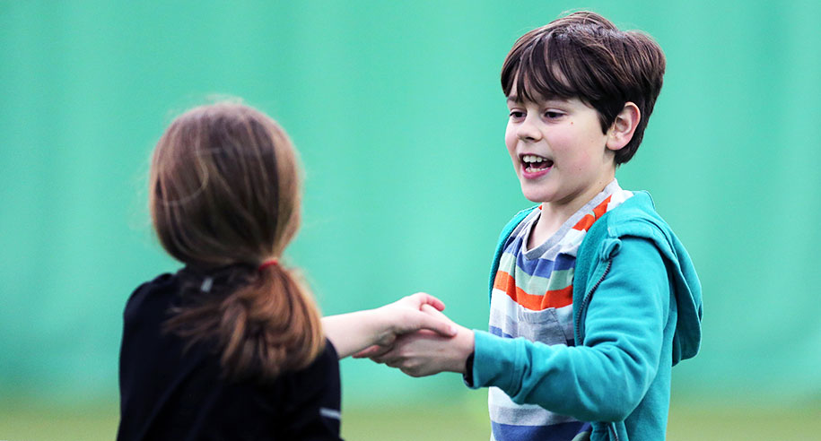 kids-boy-and-girl-shaking-hands-over-net